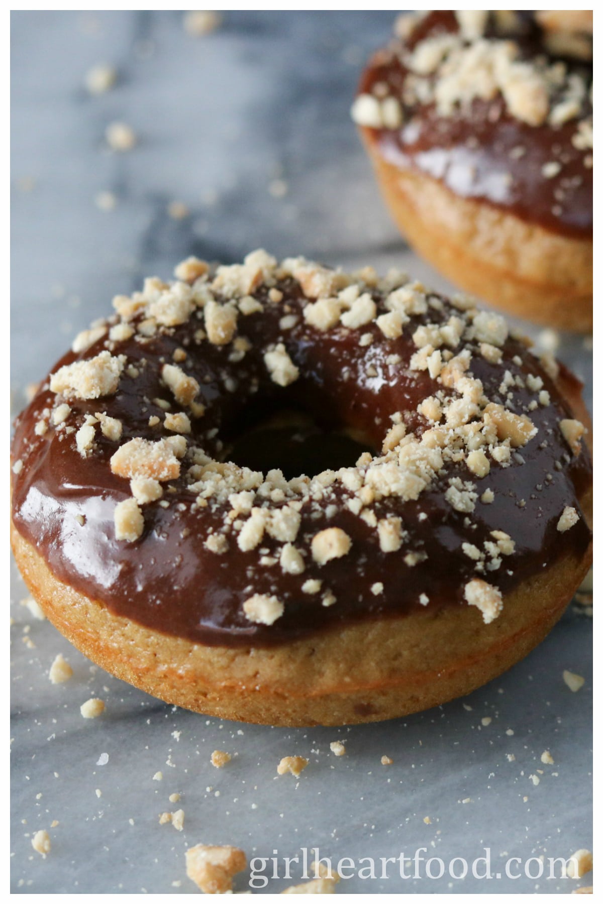 Close-up of a glazed baked donut with crushed peanuts.