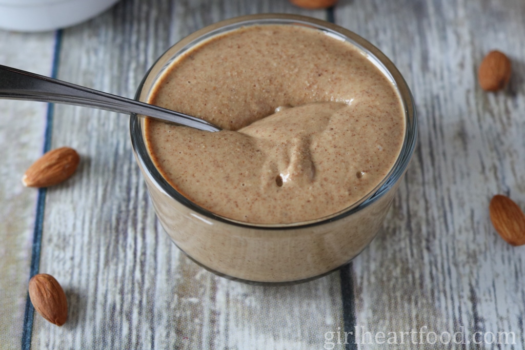 Jar of almond butter with a spoon dunked into it.