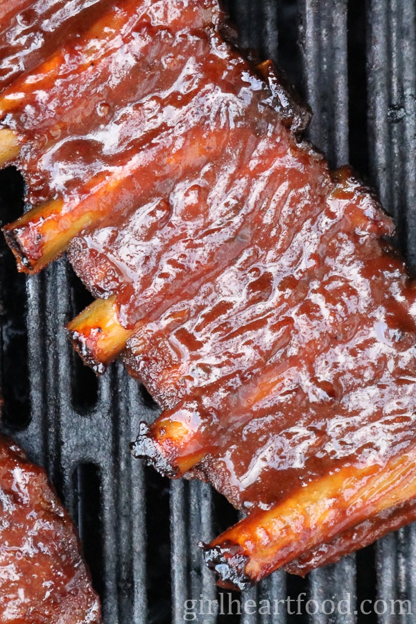 Rack of barbecue sauce covered pork ribs on the grill.