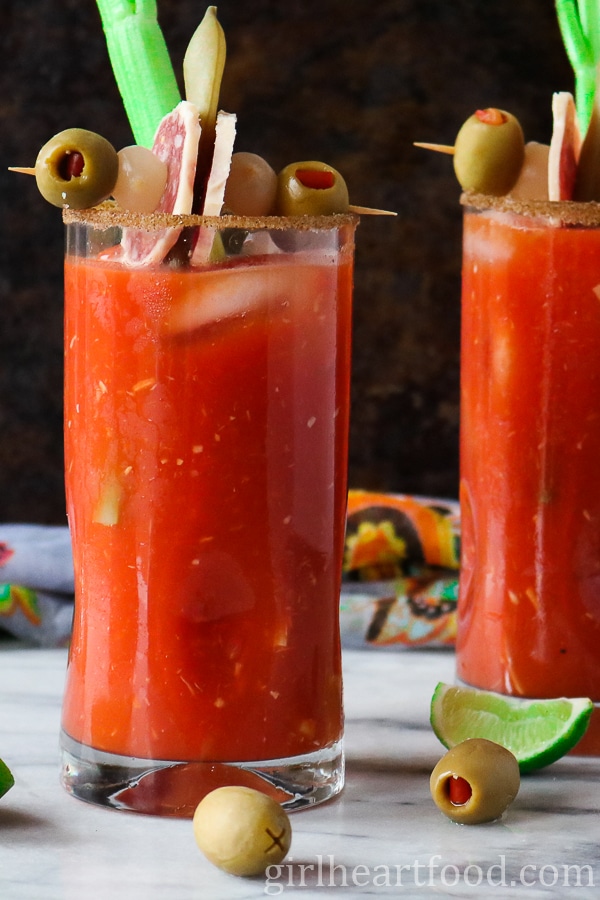 Glass of Caesar cocktail garnished with a celery stick and snack.