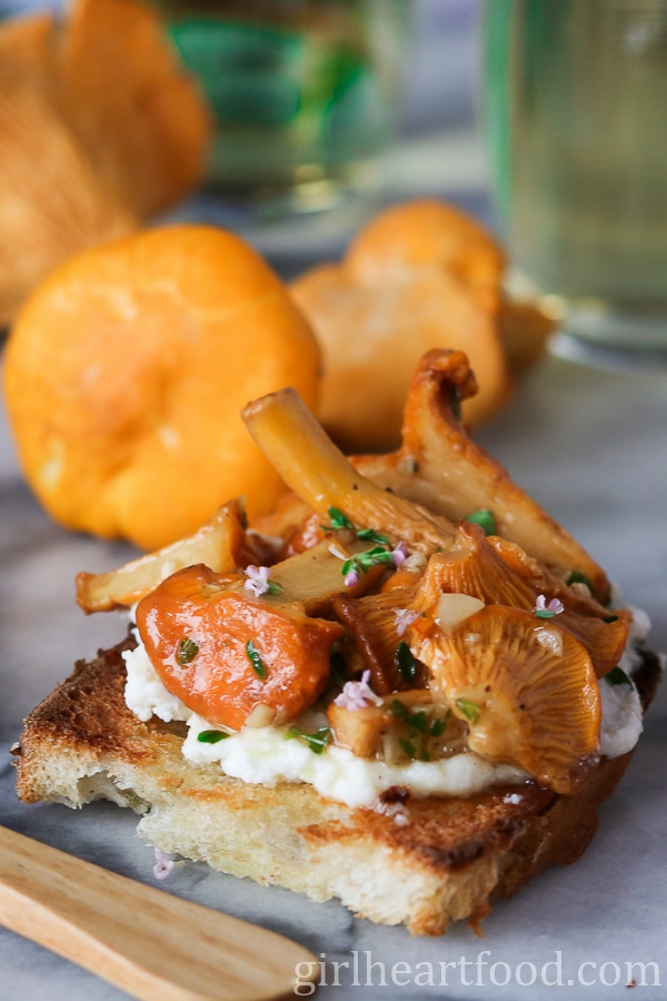 Close-up of a chanterelle mushroom crostino with ricotta and thyme.