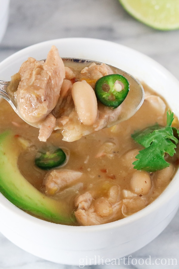 Spoonful of white chicken chili from a bowl.