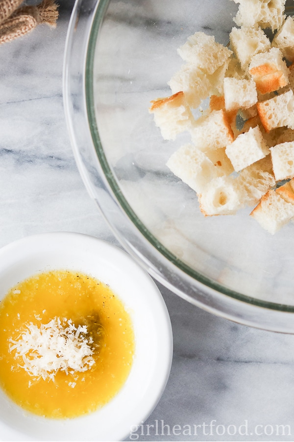 Bowl of cubed bread and a small bowl of melted butter with cheese, salt & pepper.