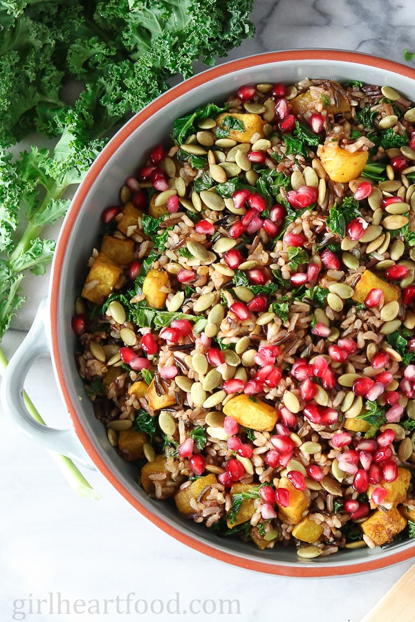 Wild rice salad in a bowl next to kale.