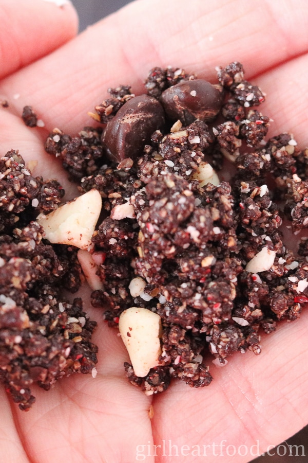 Hand holding a peppermint chocolate snack bite mixture before being rolled into balls.