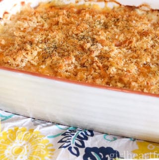 Cod au gratin in a casserole dish next to a lemon.