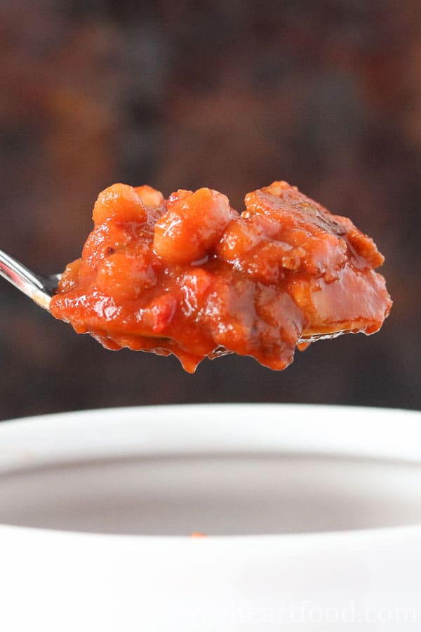 Spoonful of homemade baked beans from a bowl.