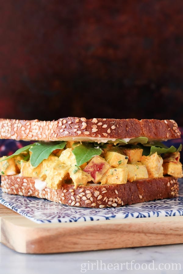 Curry chicken salad sandwich on a board.