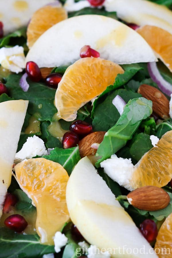 Close-up of a winter green salad that's drizzled with honey Dijon vinaigrette.