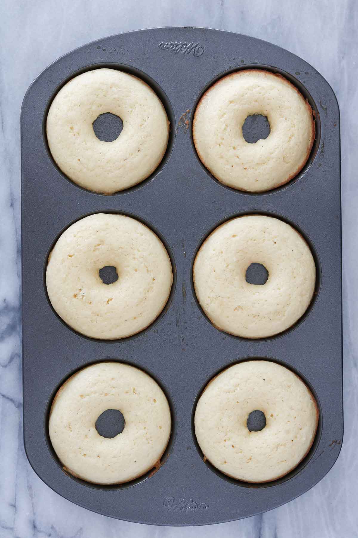 Baked donuts in a donut pan.