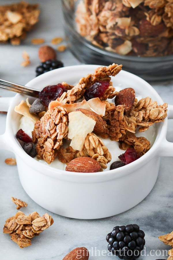 Crunchy granola and yogurt in a small white dish.