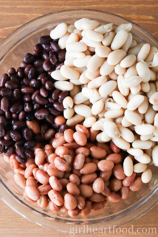 Three varieties of canned beans in a glass bowl.