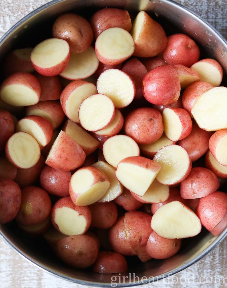 Chopped baby red potatoes in a pot.