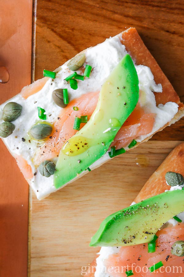 Close-up of a piece of avocado and smoked salmon flatbread.