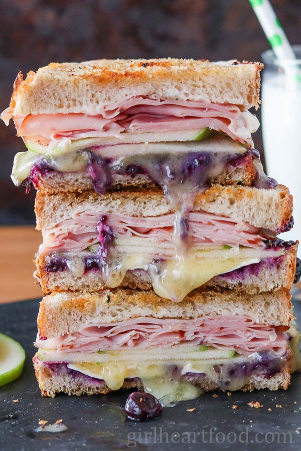 Stack of three grilled ham and Brie sandwich halves.