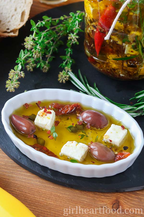 Small dish of marinated feta in oil with olives, sun-dried tomatoes and capers.