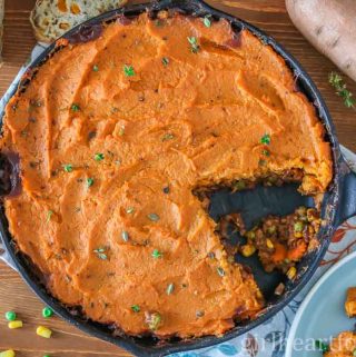 Skillet of vegan shepherd' pie with a piece taken out.
