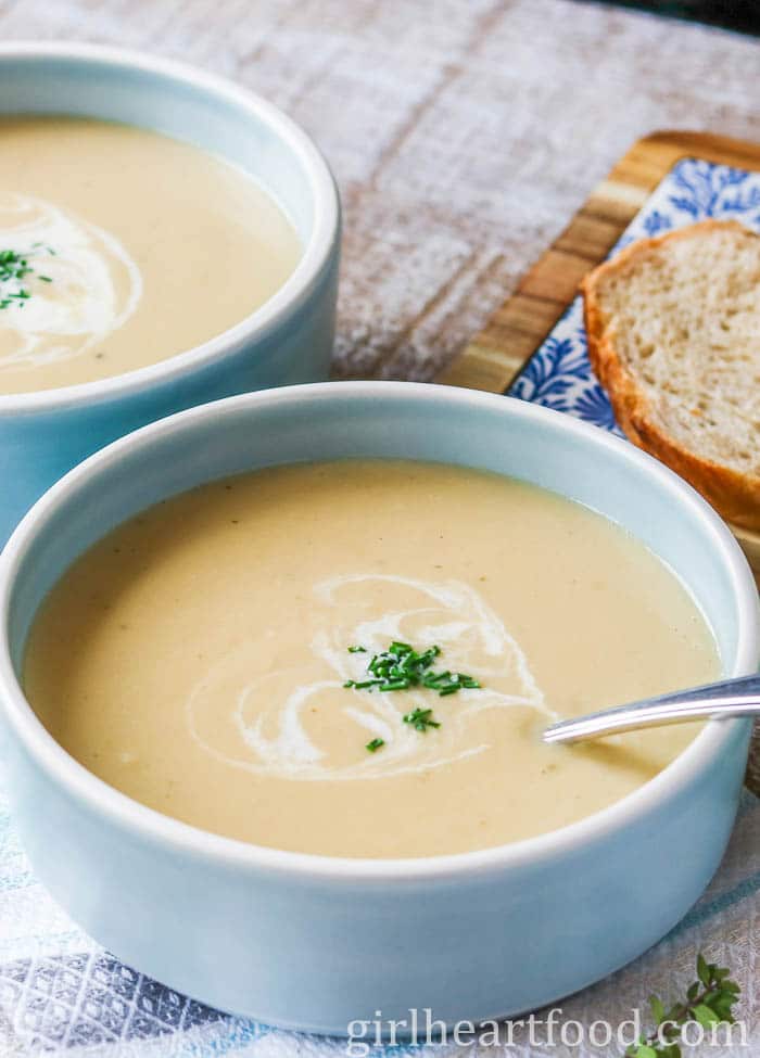 Two bowls of creamy parsnip apple soup, one in front of the other. 