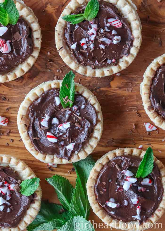 Chocolate mint avocado pudding tarts garnished with mint, candy cane and chocolate.