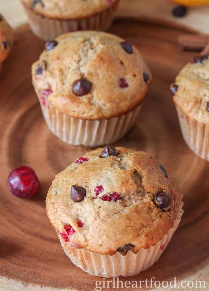 Cranberry orange chocolate chip muffins alongside a cranberry.