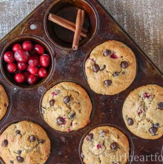 Cranberry orange chocolate chip muffins in a muffin pan.