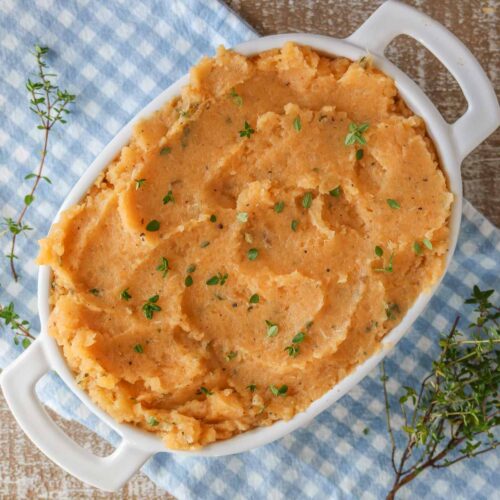 Mashed turnip in a serving dish garnished with thyme.