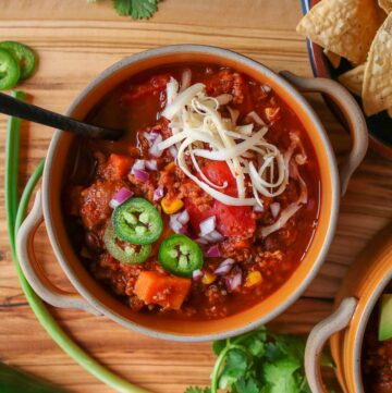 Bowl of turkey quinoa chili garnished with toppings.
