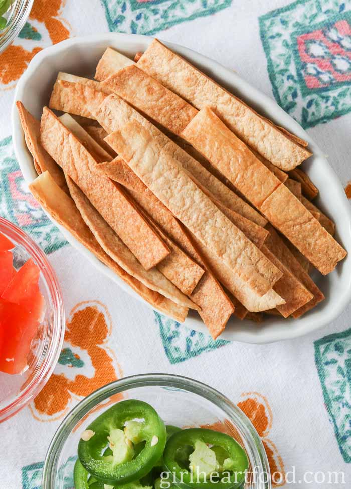 Baked tortilla strips in a small white dish.