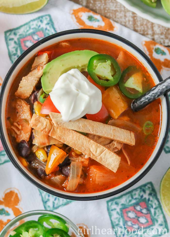 Bowl of chicken taco soup garnished with toppings and dollop of yogurt.