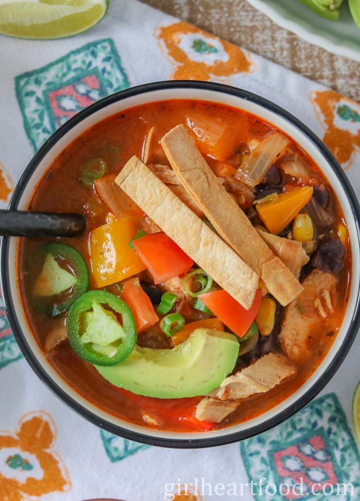 Bowl of chicken taco soup garnished with toppings.