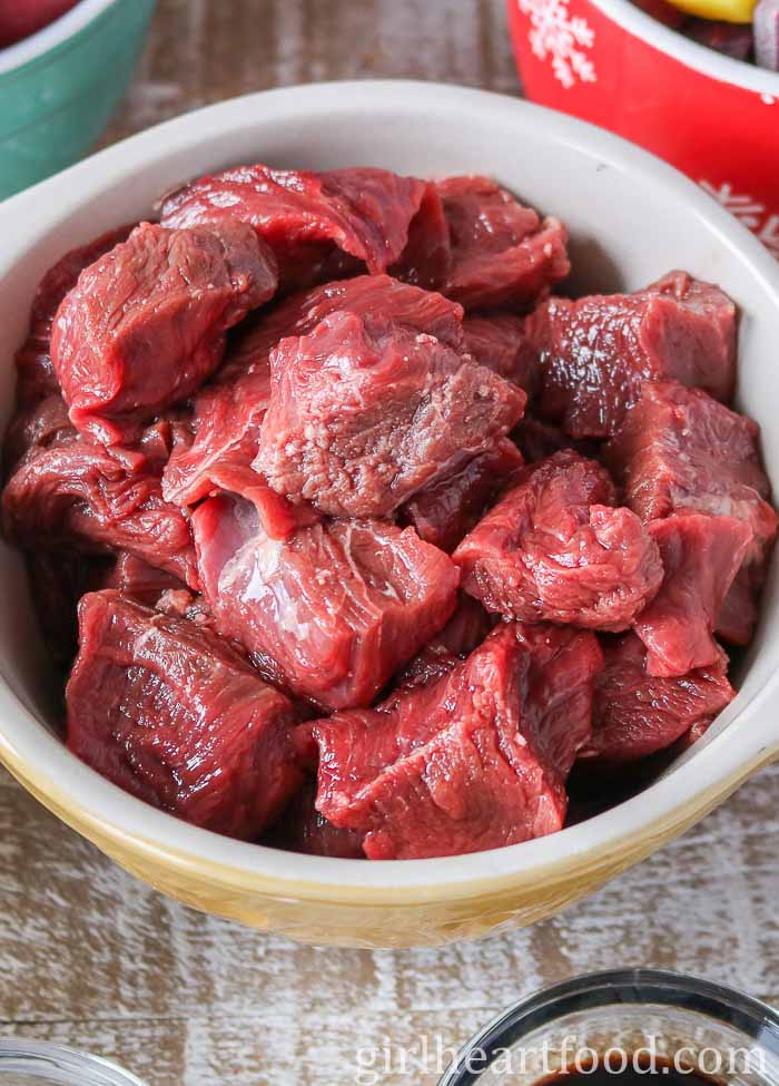 A bowl of raw moose meat chunks.