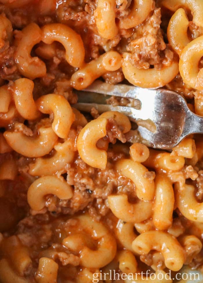 Close-up of cheeseburger mac with a fork resting in it.