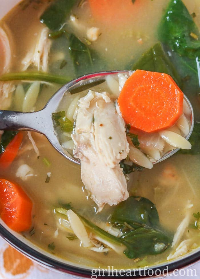 Spoonful of lemon chicken orzo soup from a bowl.