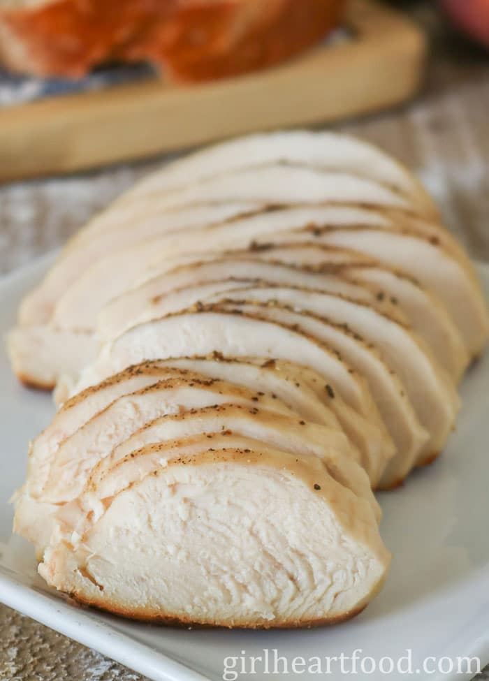 Cooked sliced chicken breast on a white plate.