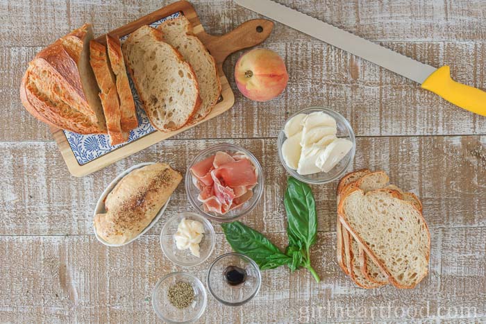 Ingredients for a chicken prosciutto sandwich recipe alongside a knife.