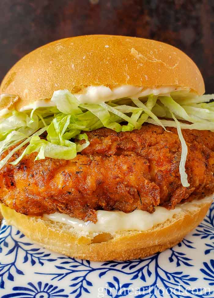 Close-up of a crispy chicken burger with mayo and lettuce.