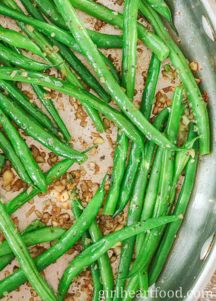 Green beans with garlic in a stainless steel skillet.