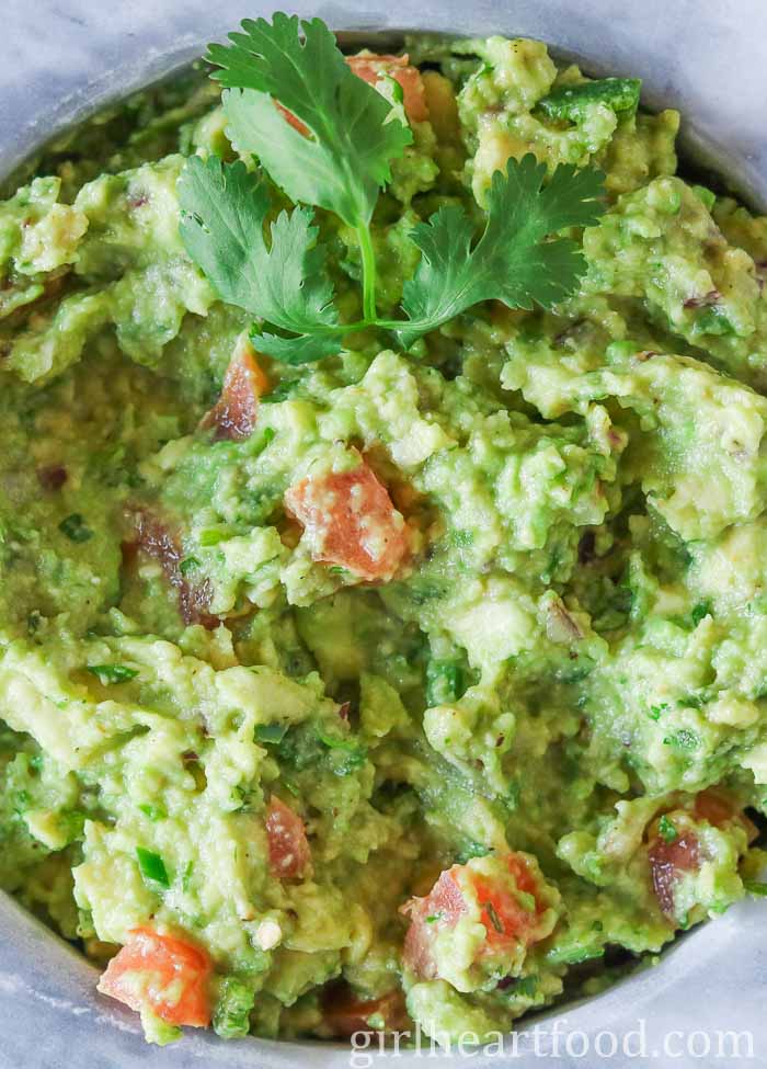 Close-up of a bowl of guacamole garnished with cilantro.