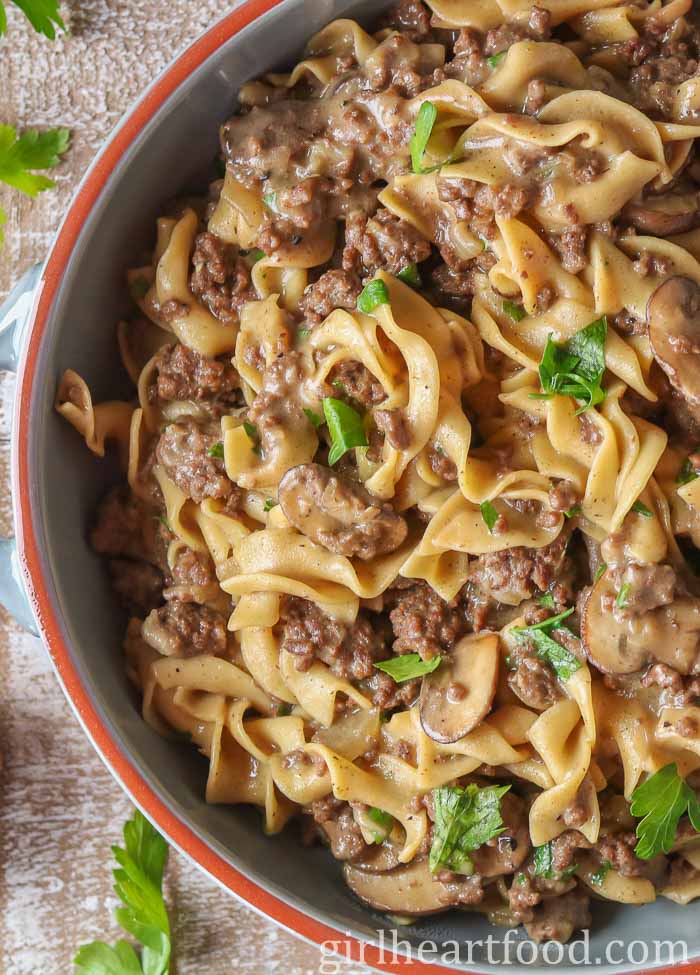 Close-up of ground beef stroganoff in a dish garnished with parsley.