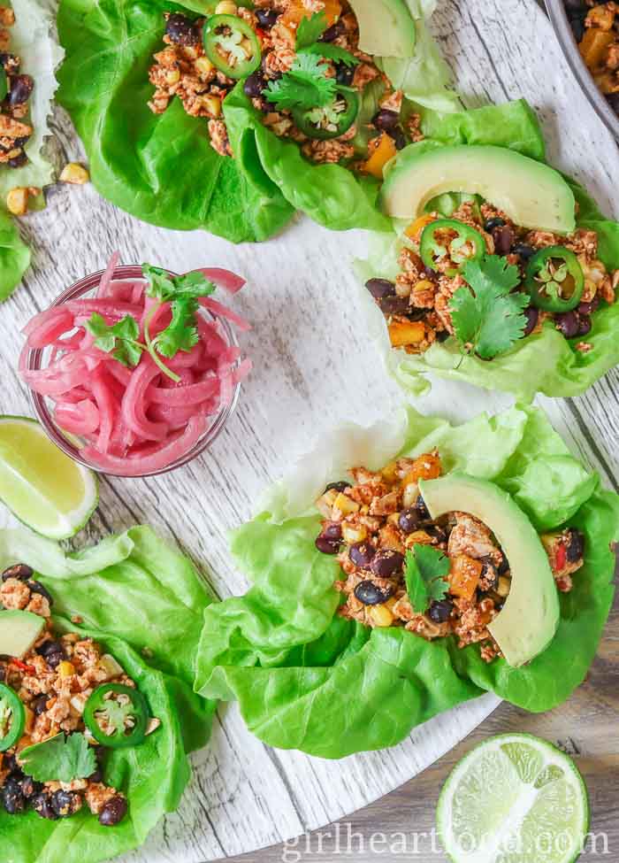 Lettuce wraps made with tofu scramble next to a dish of pickled red onion.