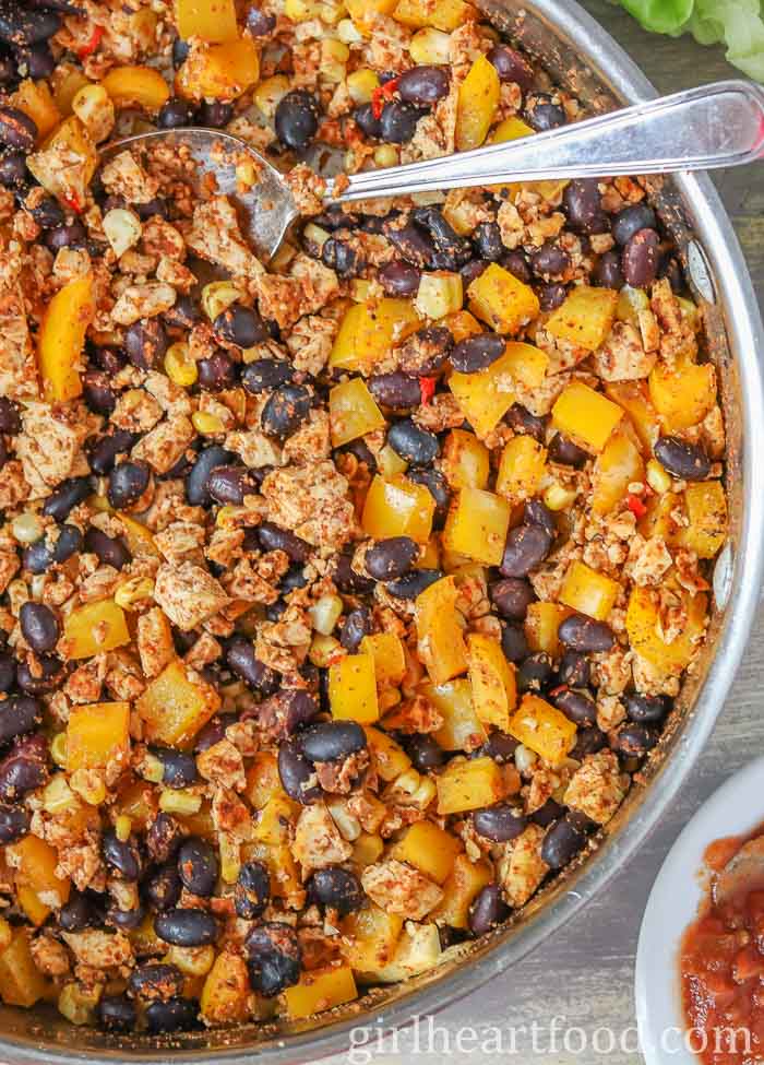 Tofu scramble in a pan with a spoon resting in it.