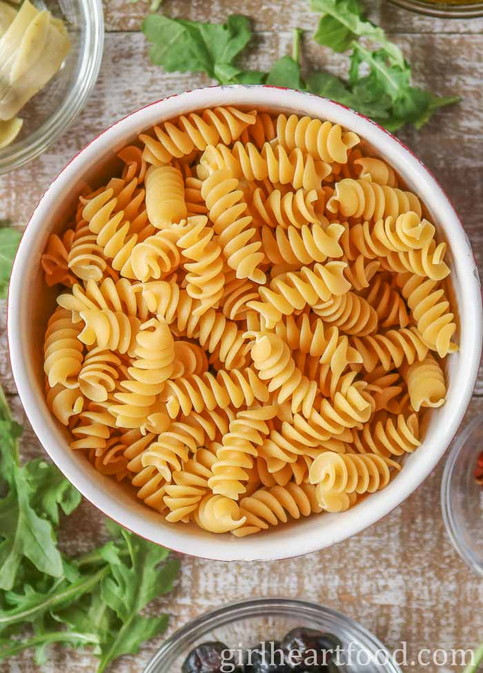 Bowl of uncooked rotini pasta.