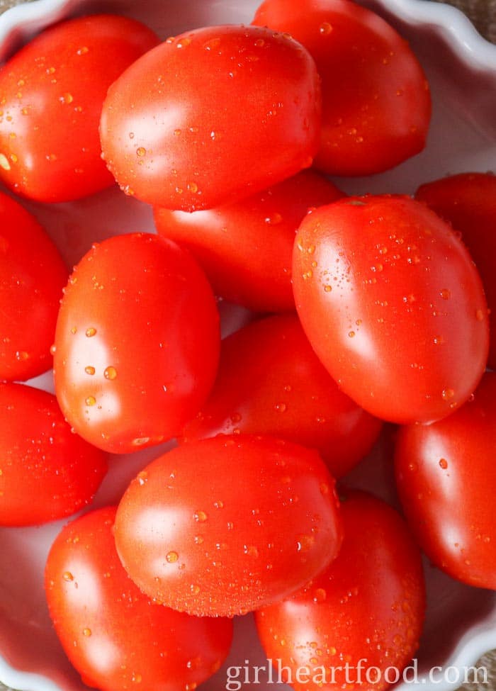 Close-up of fresh Roma tomatoes in a bowl.