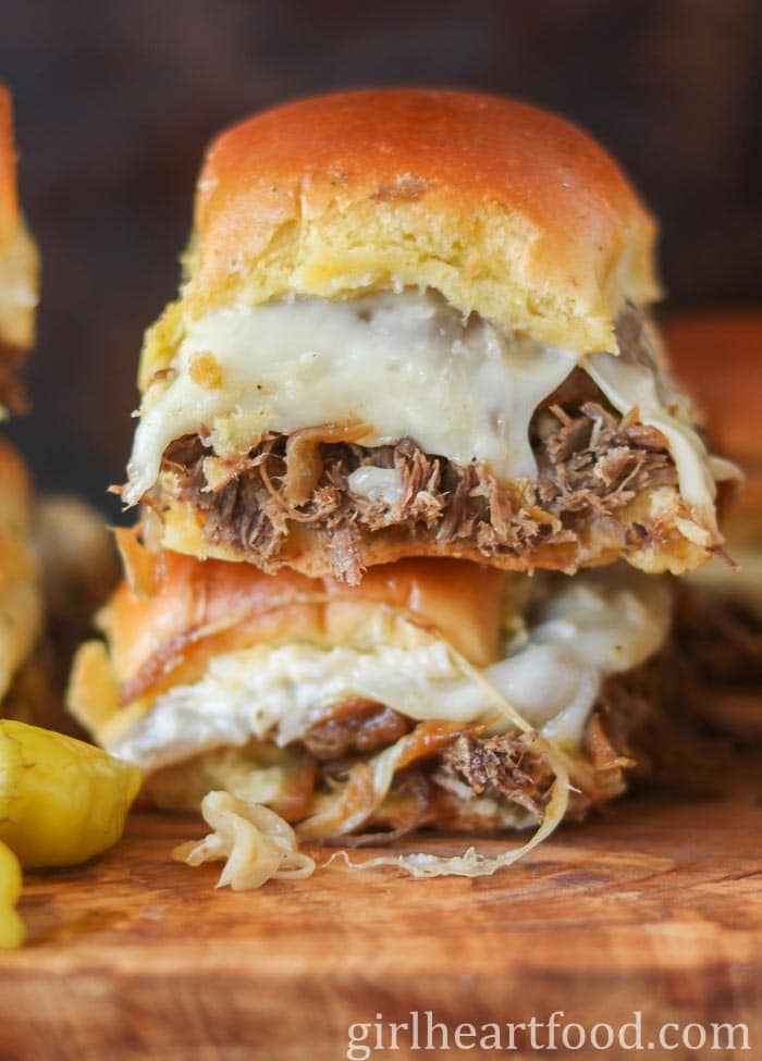 Stack of two roast beef and cheese slider sandwiches.