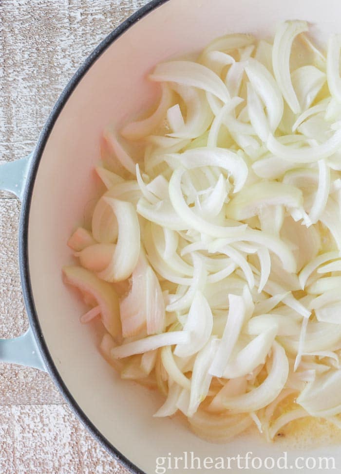 Sliced onions in a pan before being cooked.