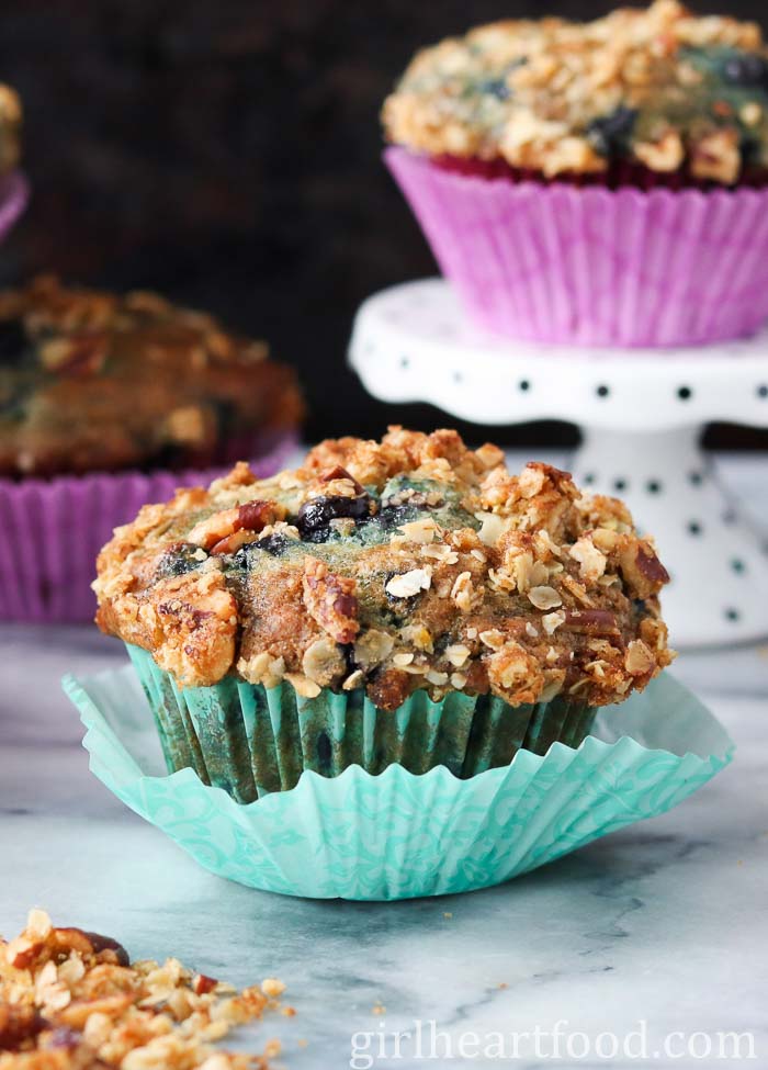 Blueberry muffin wrapped in a teal muffin liner.