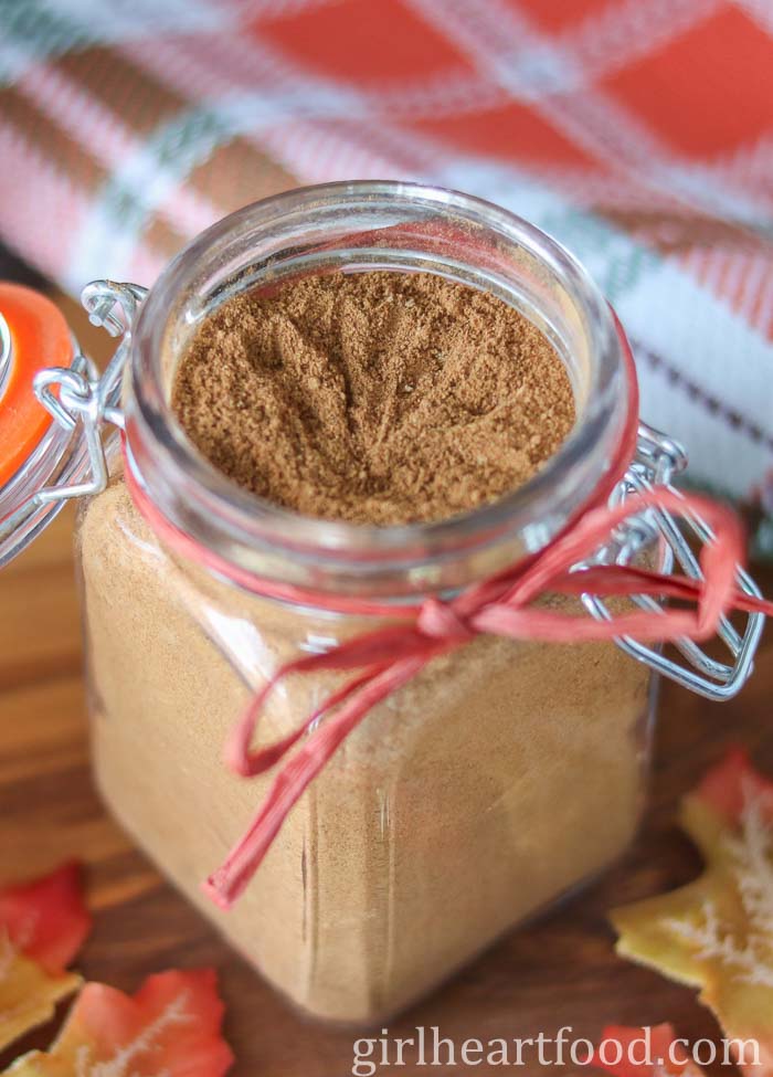 Jar of homemade pumpkin pie spice with a ribbon tied around it.