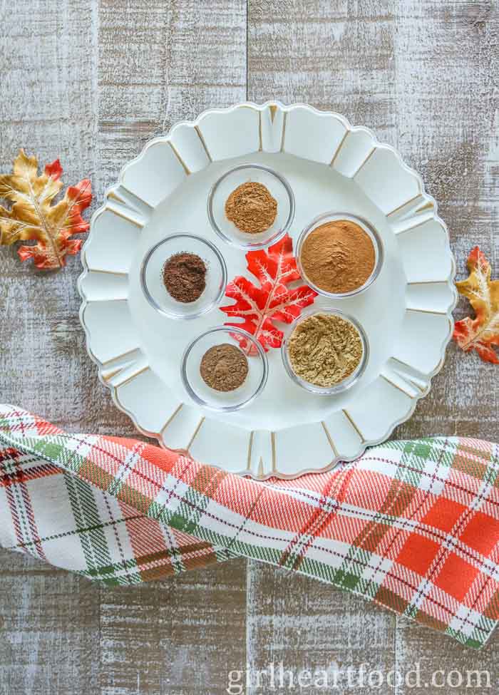 Ingredients for a pumpkin spice recipe on a white platter.