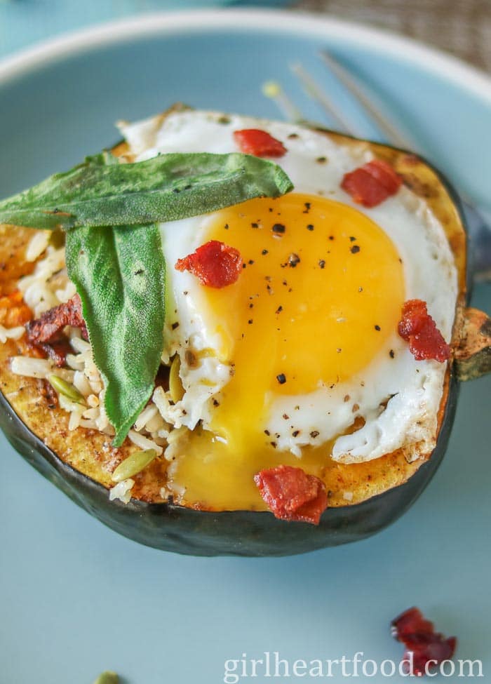 Stuffed acorn acorn squash half topped with bacon, sage and a fried egg (with the yolk broke).