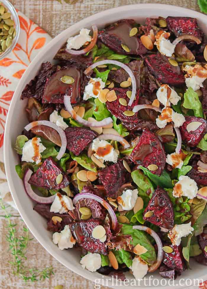 Close-up of roasted beet salad in a bowl with balsamic vinaigrette drizzled over top.